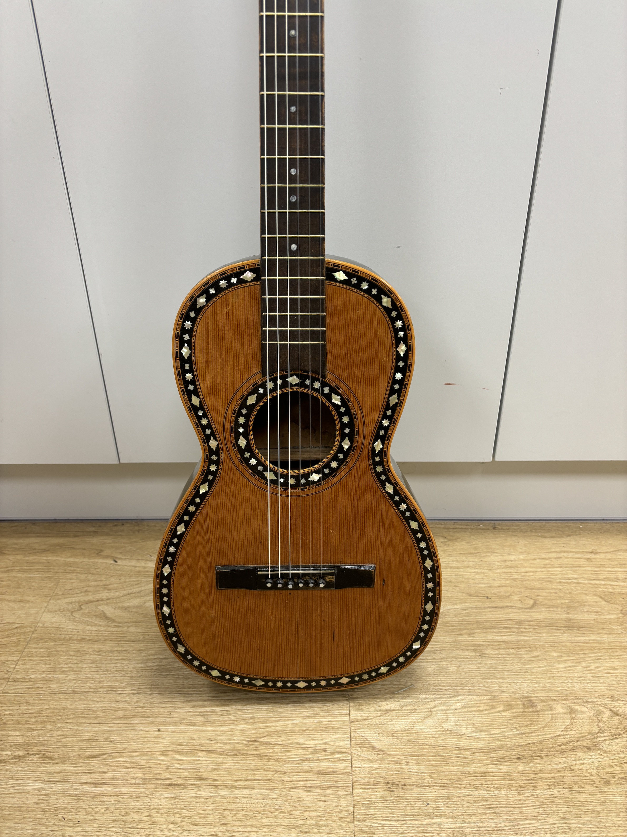 A mid-19th century Continental six string parlour guitar, soundboard inlaid with mother of pearl, rosewood back, length of body 45.5cm, overall length 92cm